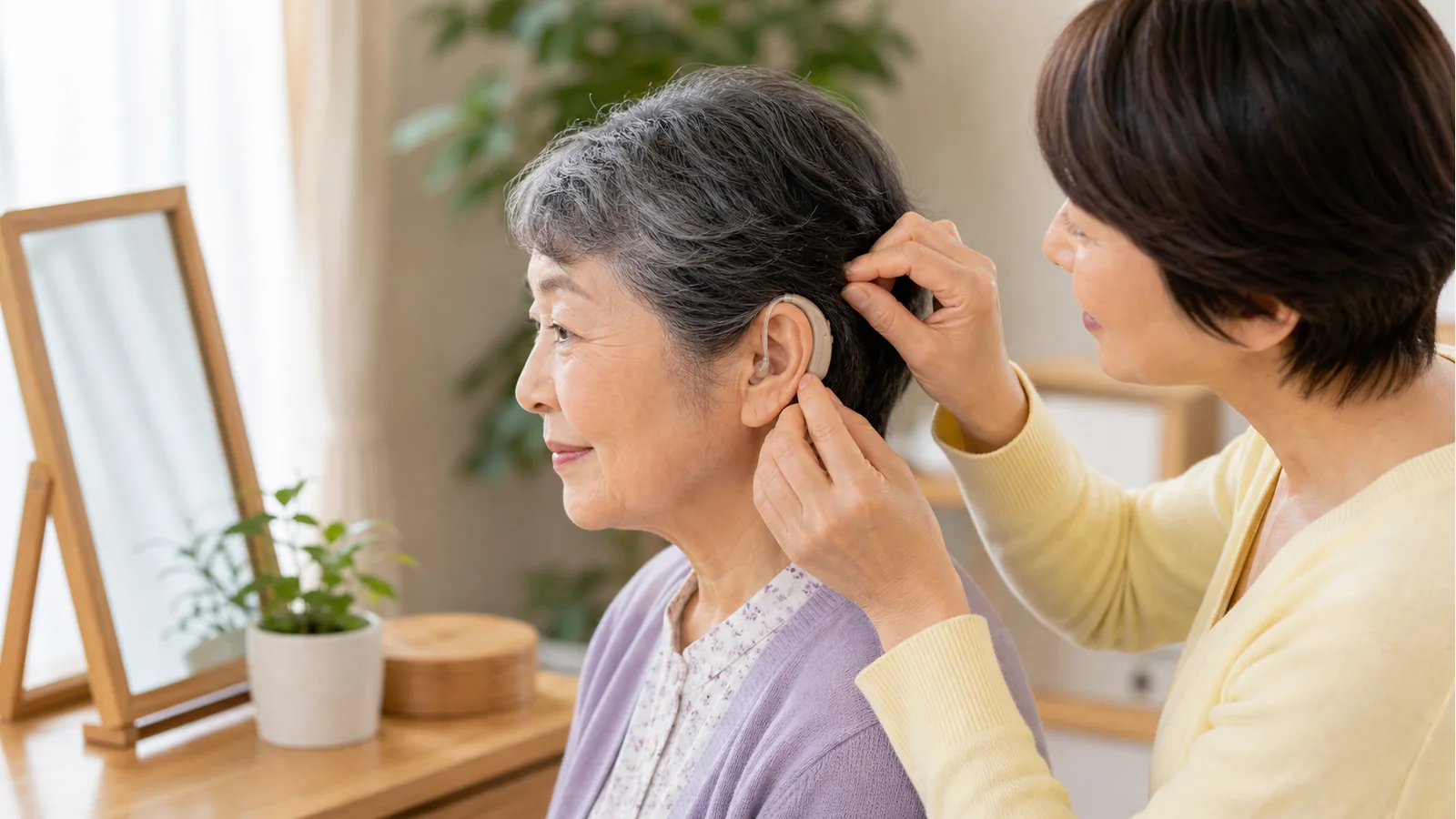 高齢者が集音器を装着しやすいか家族で確認している様子