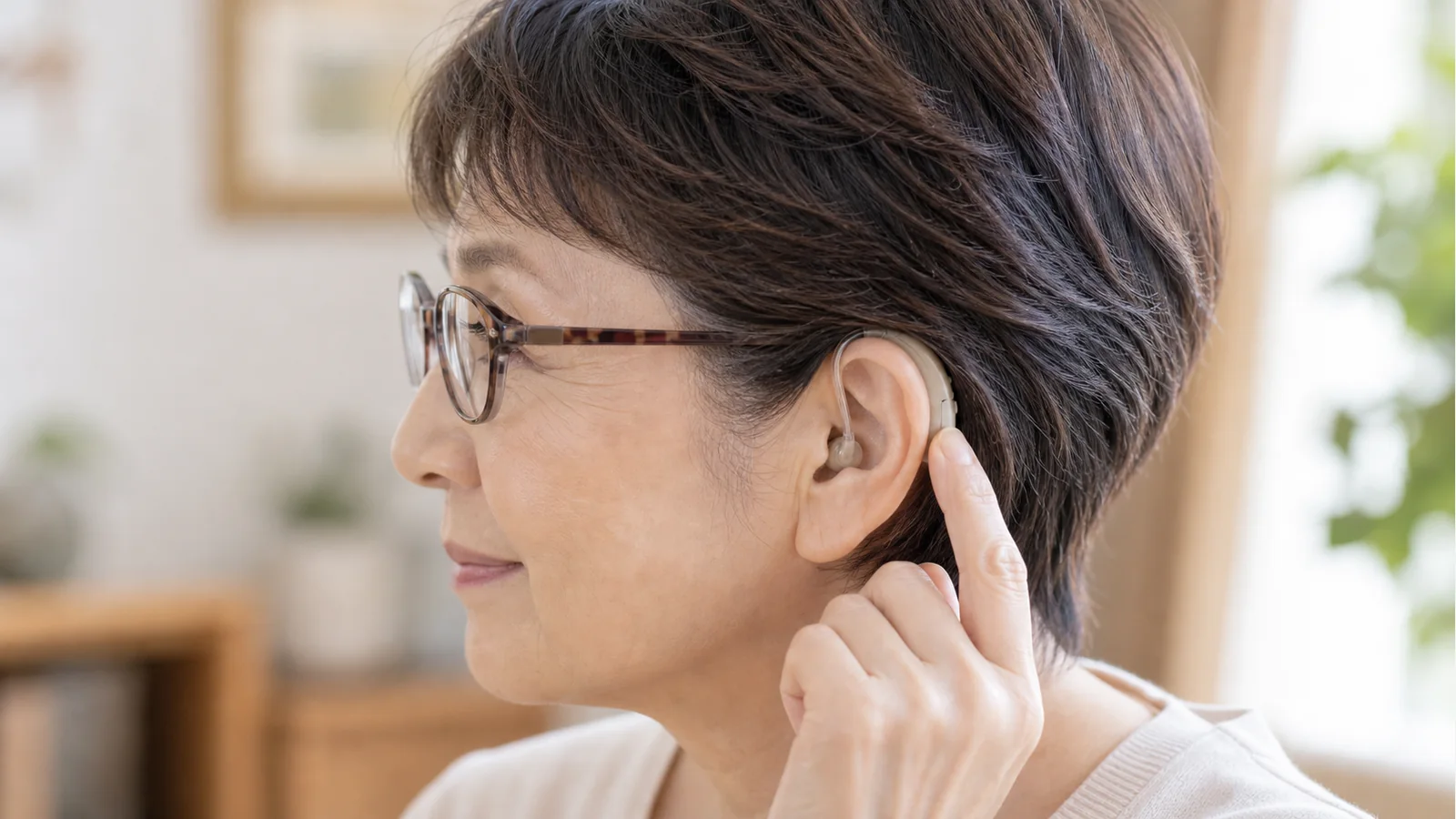 メガネと耳かけ型集音器の装着感を確認している様子