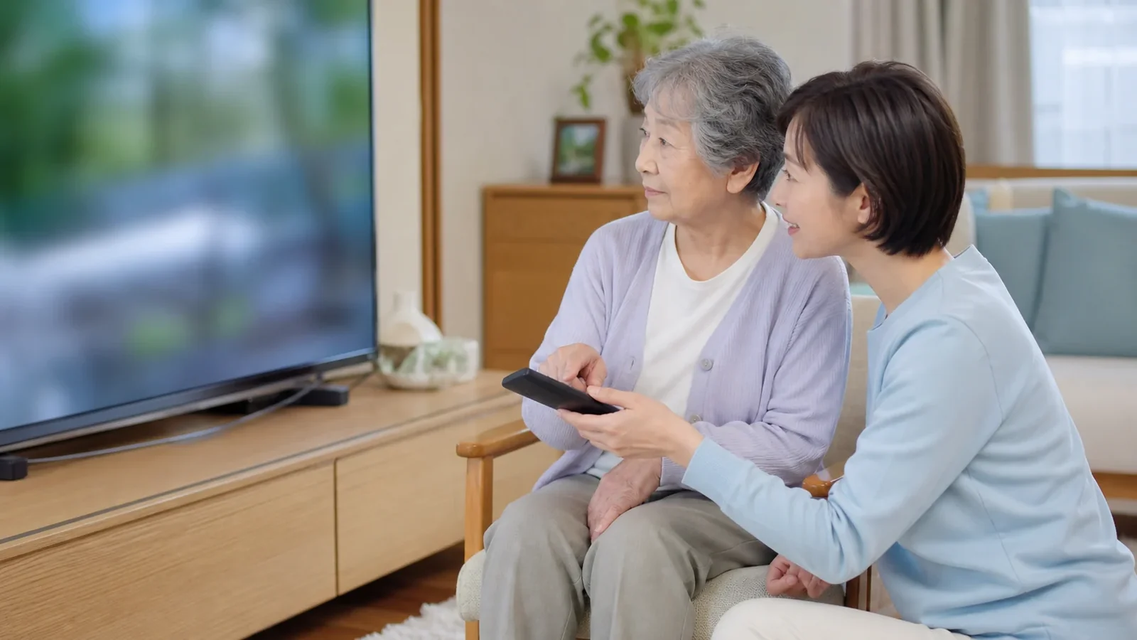 高齢の親と家族がテレビの音声設定を一緒に確認する様子